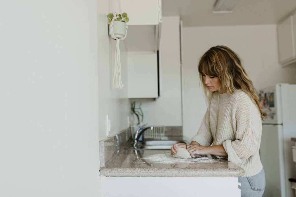 
Woman kneading sourdough in her kitchen during quarantine